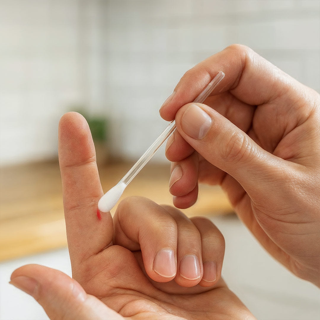 Ein Serum wird mit der Wattenspitze direkt und präzise auf eine kleine Schnittwunde am Finger aufgetragen.