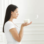 Eine Frau hält ein leichtes Octasleep Smart Element in den Händen – Symbol für Leichtigkeit und Atmungsaktivität.